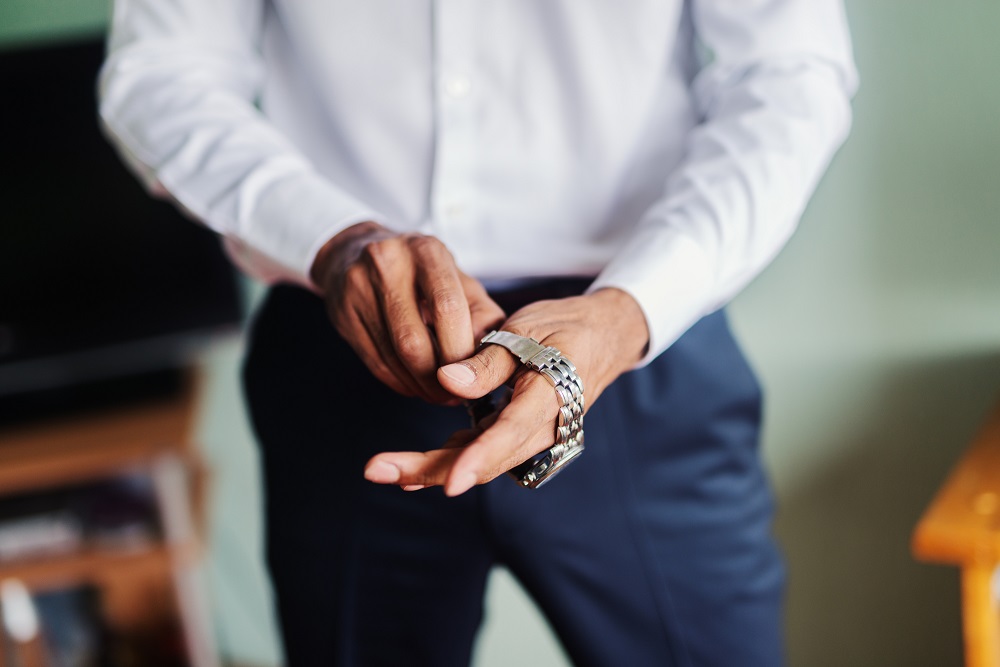 man adjusting metal watch