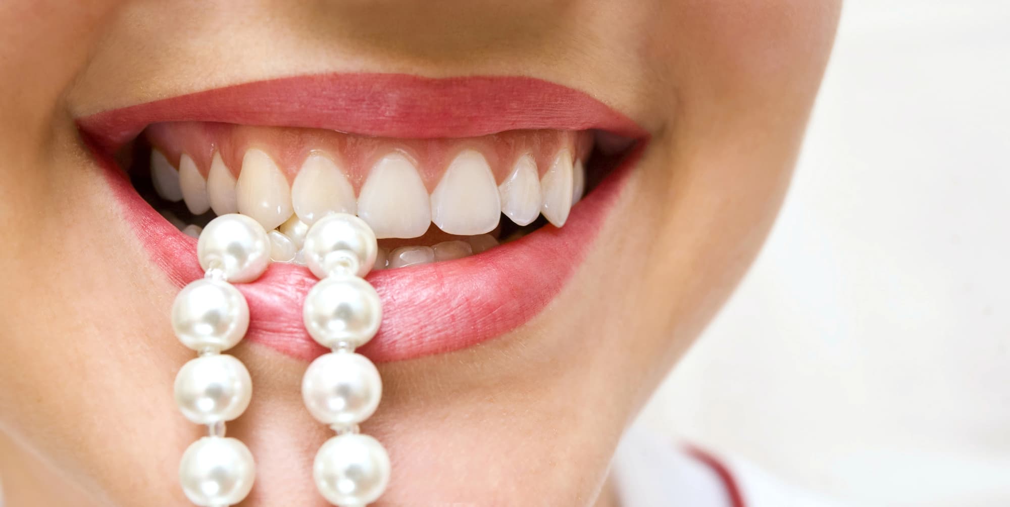 woman biting pearls