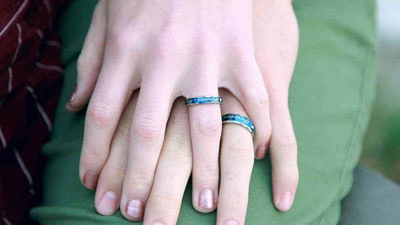 couple wearing promise rings on fingers